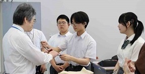 写真：ロジャーマイクを大学の先生に渡している様子