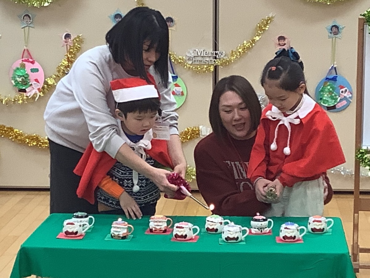 キャンドルに親子で火を着けている様子