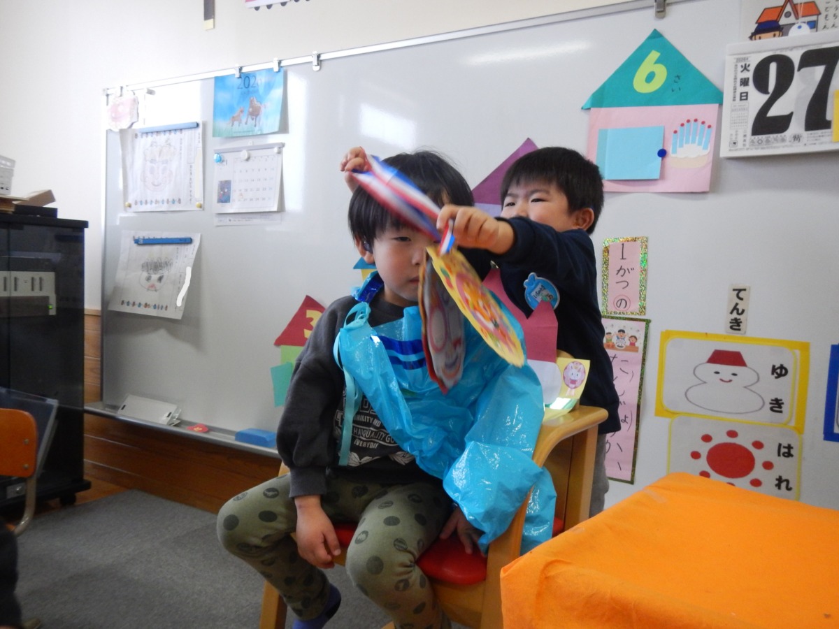 友達から誕生カードを首にかけてもらっている様子の写真