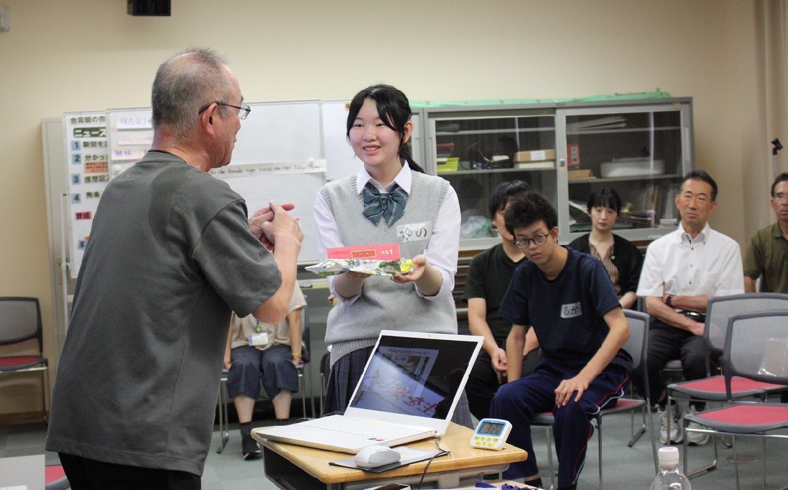講師にお礼を渡す女子生徒の写真