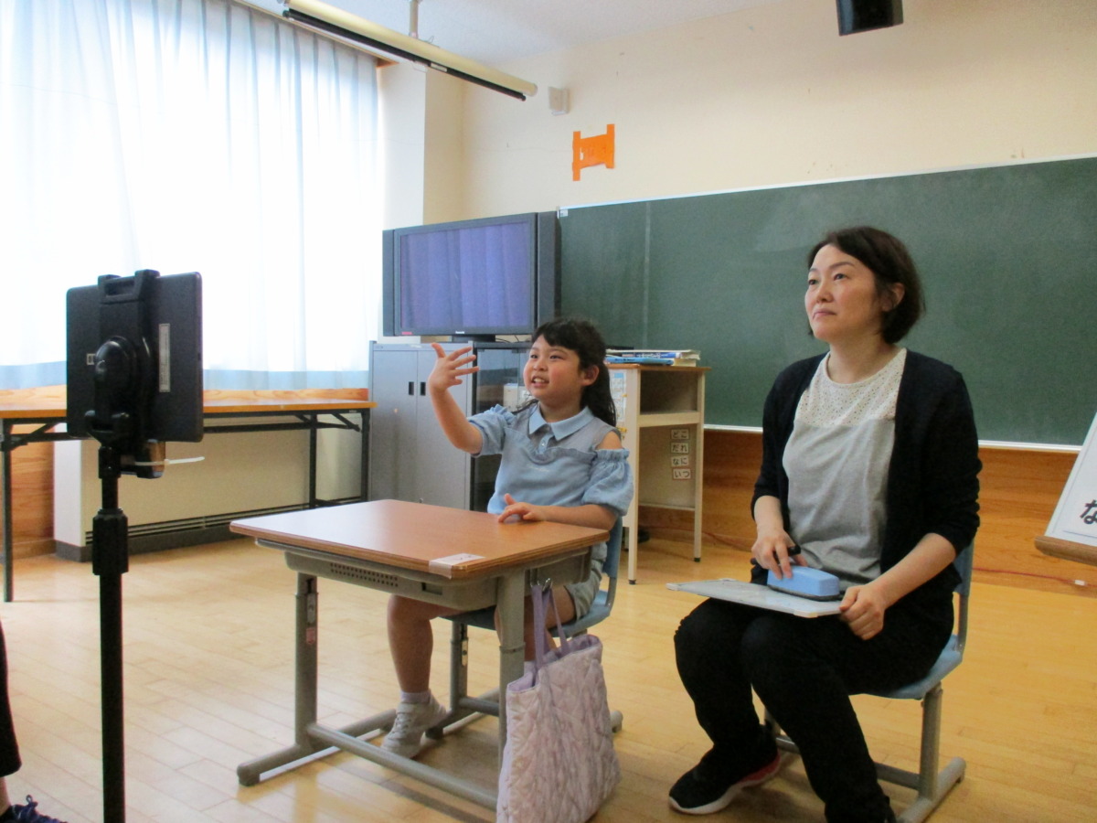 県外の聴覚支援学校の児童とオンラインで交流している様子の写真です。