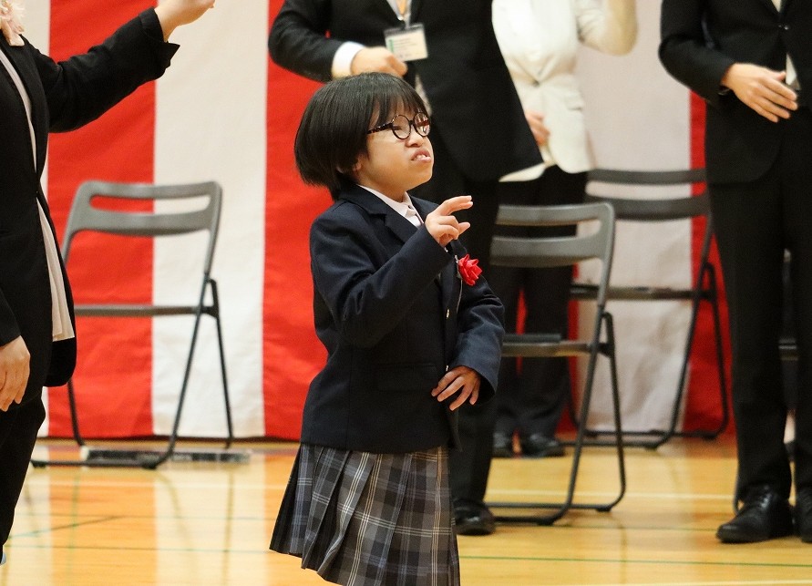 中学部の新入生１名が校歌を手話を用いて歌っている写真
