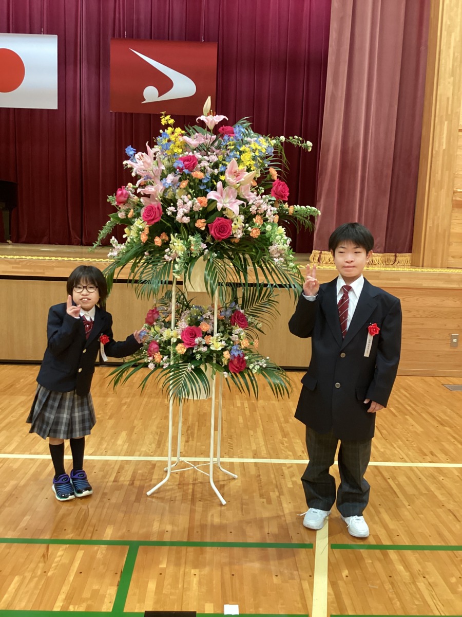 入学式花の前で中1の2ショット写真