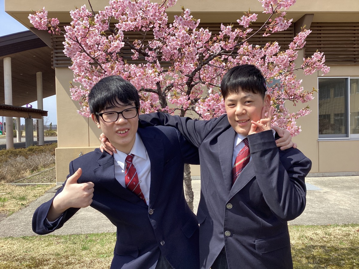 桜の下で中３の二人が肩を組む写真