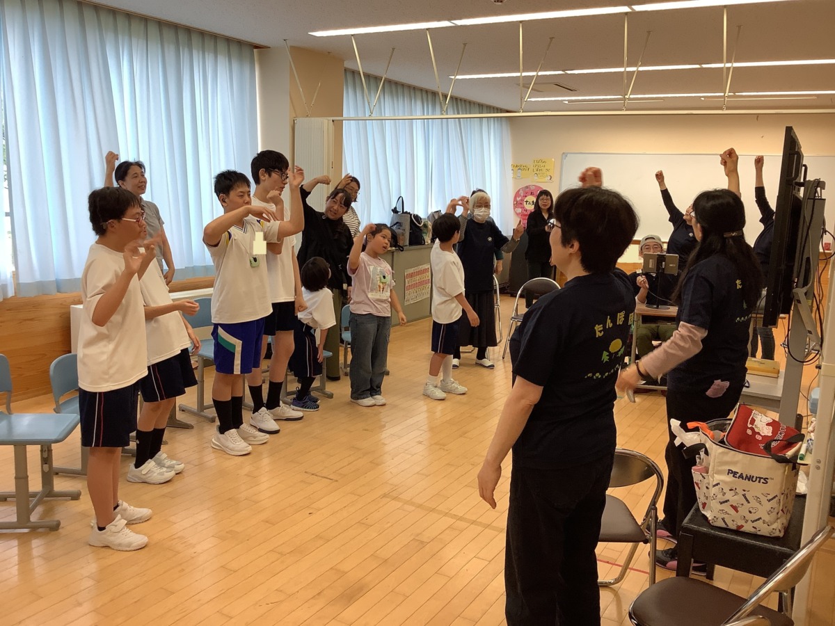 全員でにじの歌の手話を表現している様子。