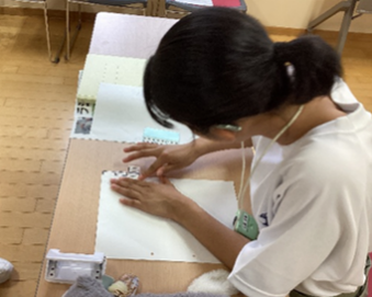 書類を丁寧にファイルにとじている様子です。