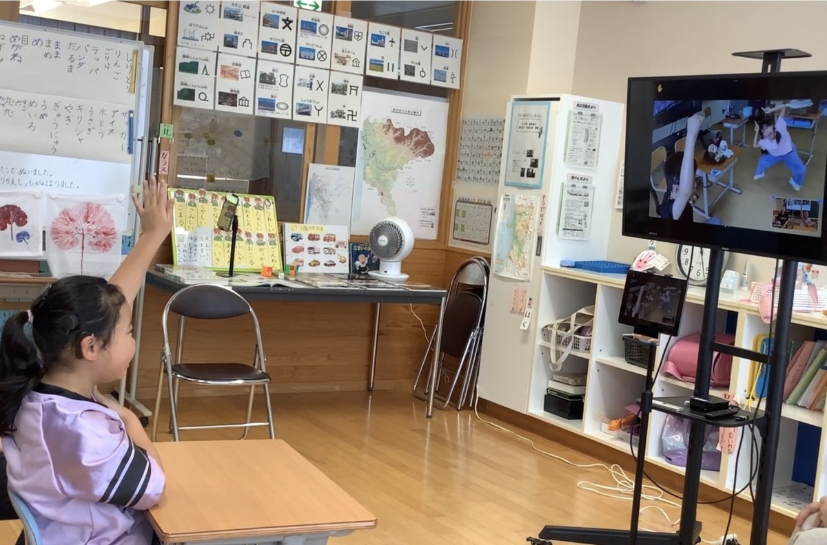 相手のユニークなジェスチャーを見て当てようと挙手している写真