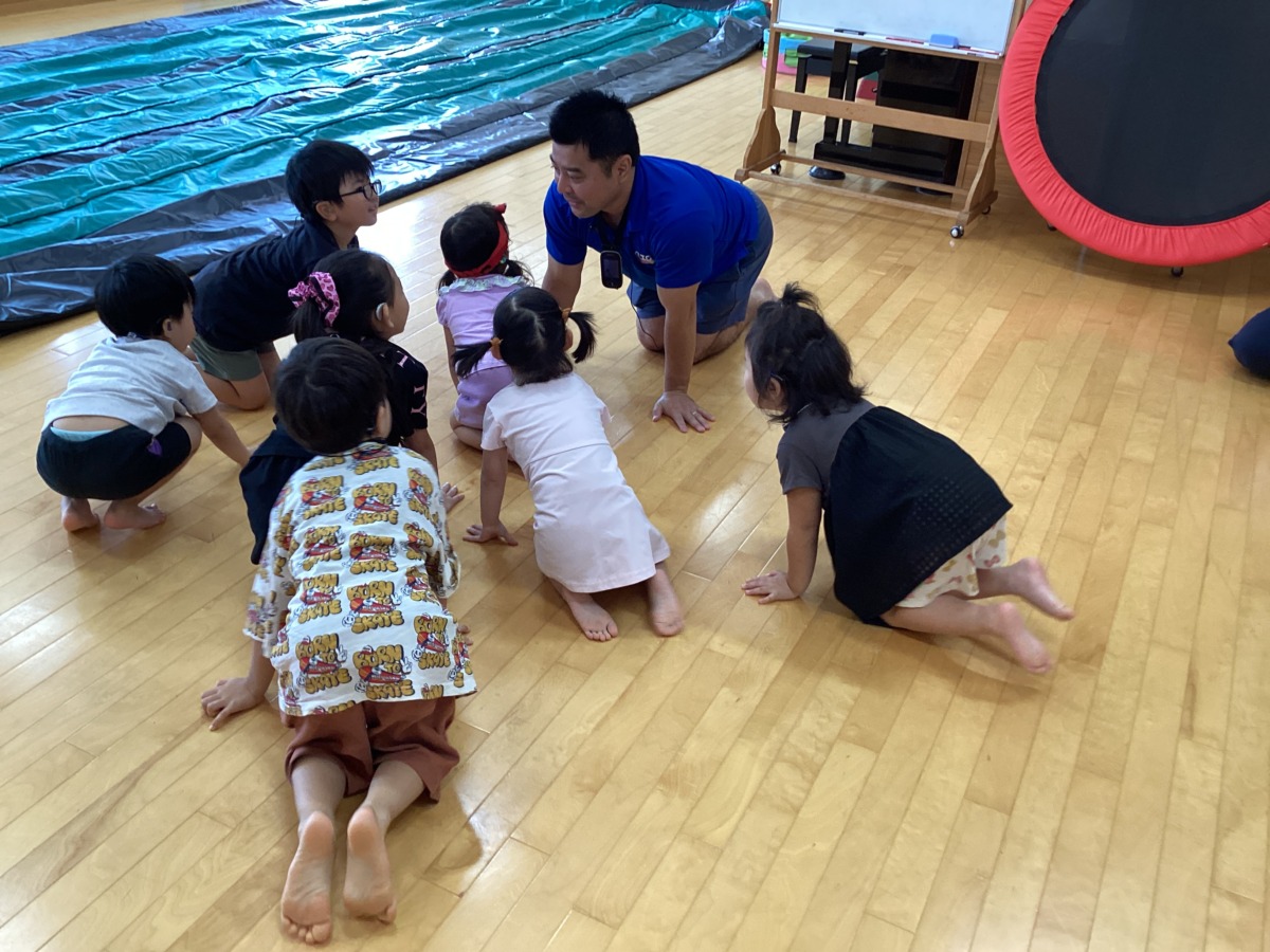 松村先生をよく見て、子どもたちがみんなでライオンのポーズをまねしている写真