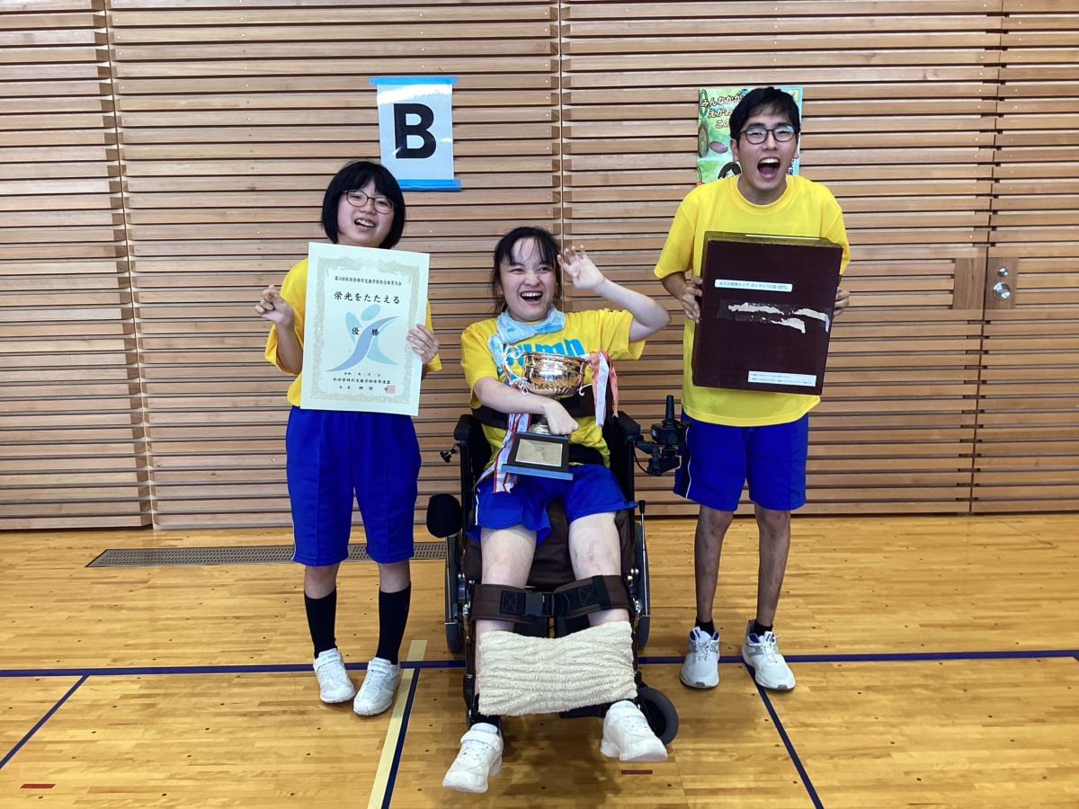 写真：賞状、カップ、盾を持つ生徒