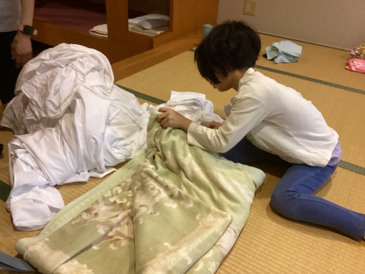 写真:自分でベットメイキングをする児童