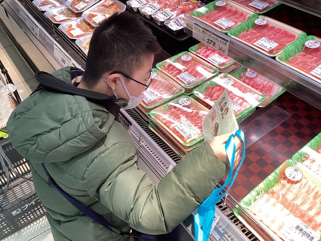 写真：買い物メモと商品を見比べる児童