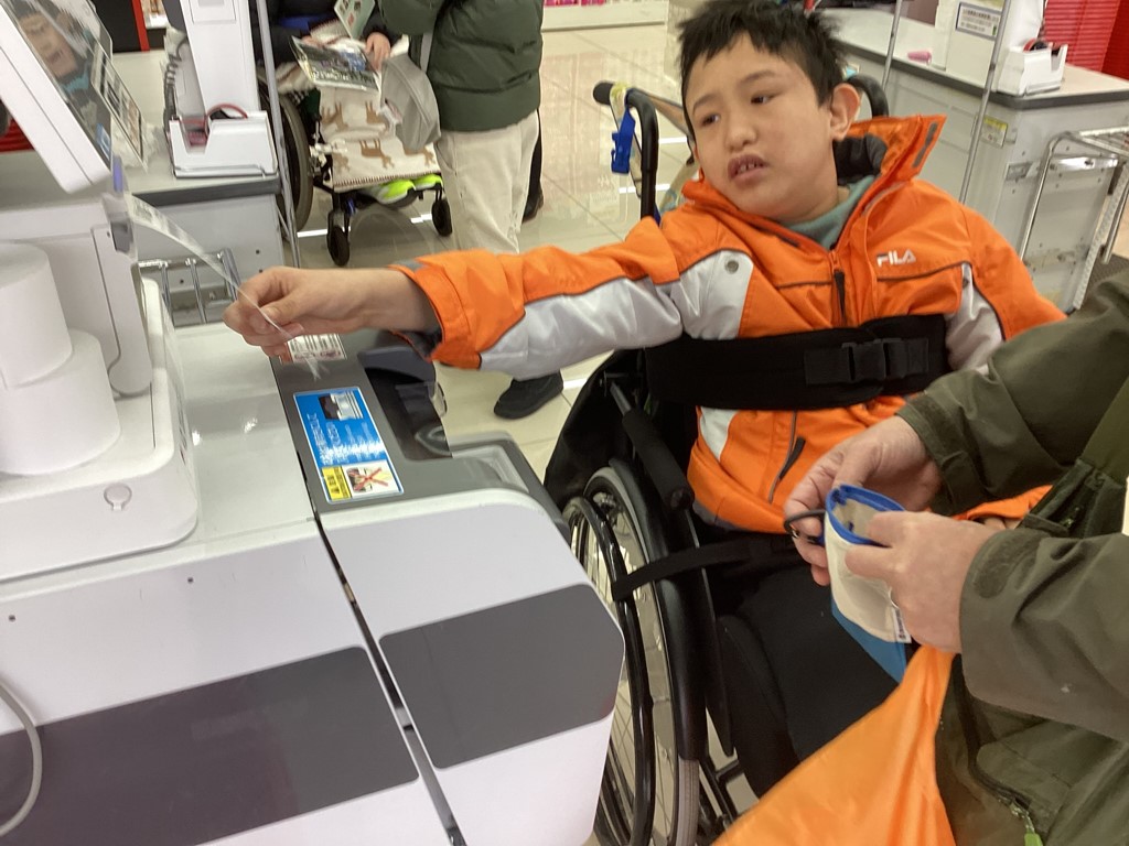 写真：セルフレジで支払をする児童