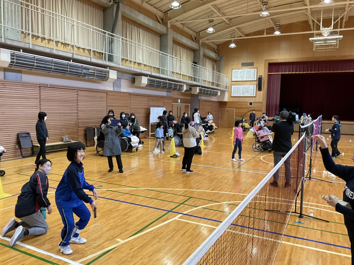 写真：体育館でグループに分かれてシャトルを打ち合う児童生徒