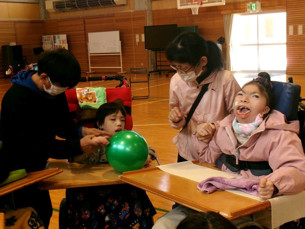 写真：友達にボールを手渡そうとする児童