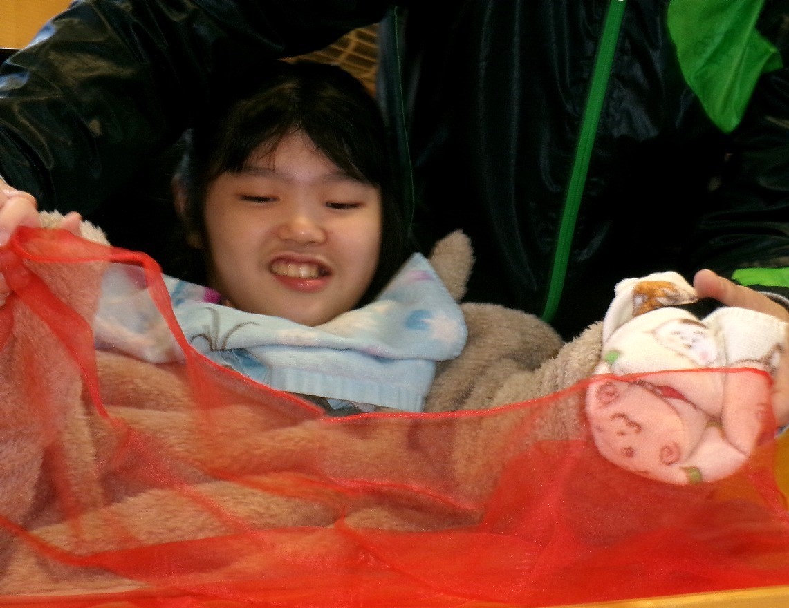 写真：スカーフに触って笑顔を見せる児童