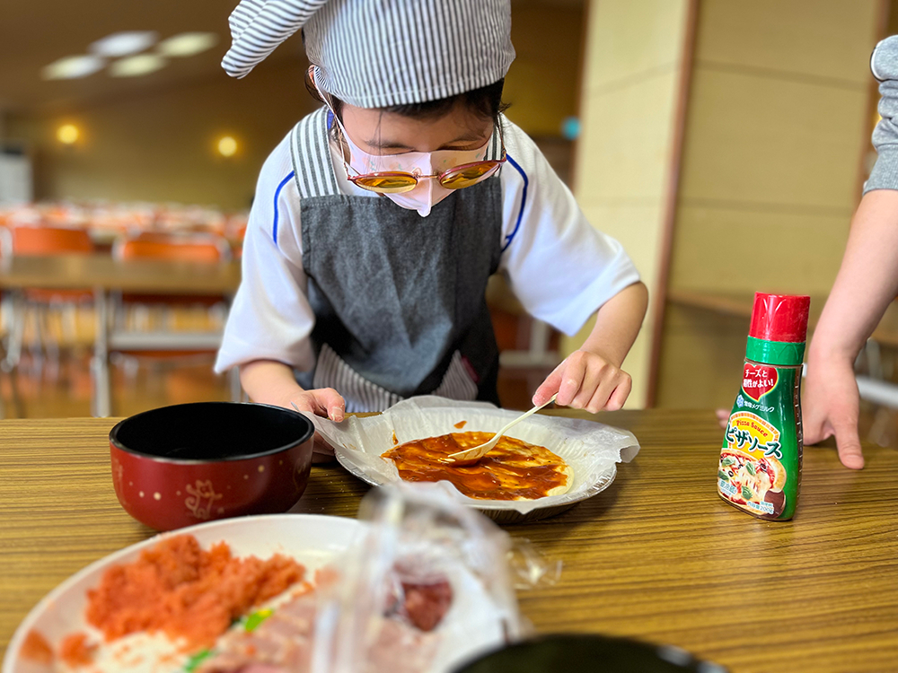 写真：ピザに具材をのせる様子