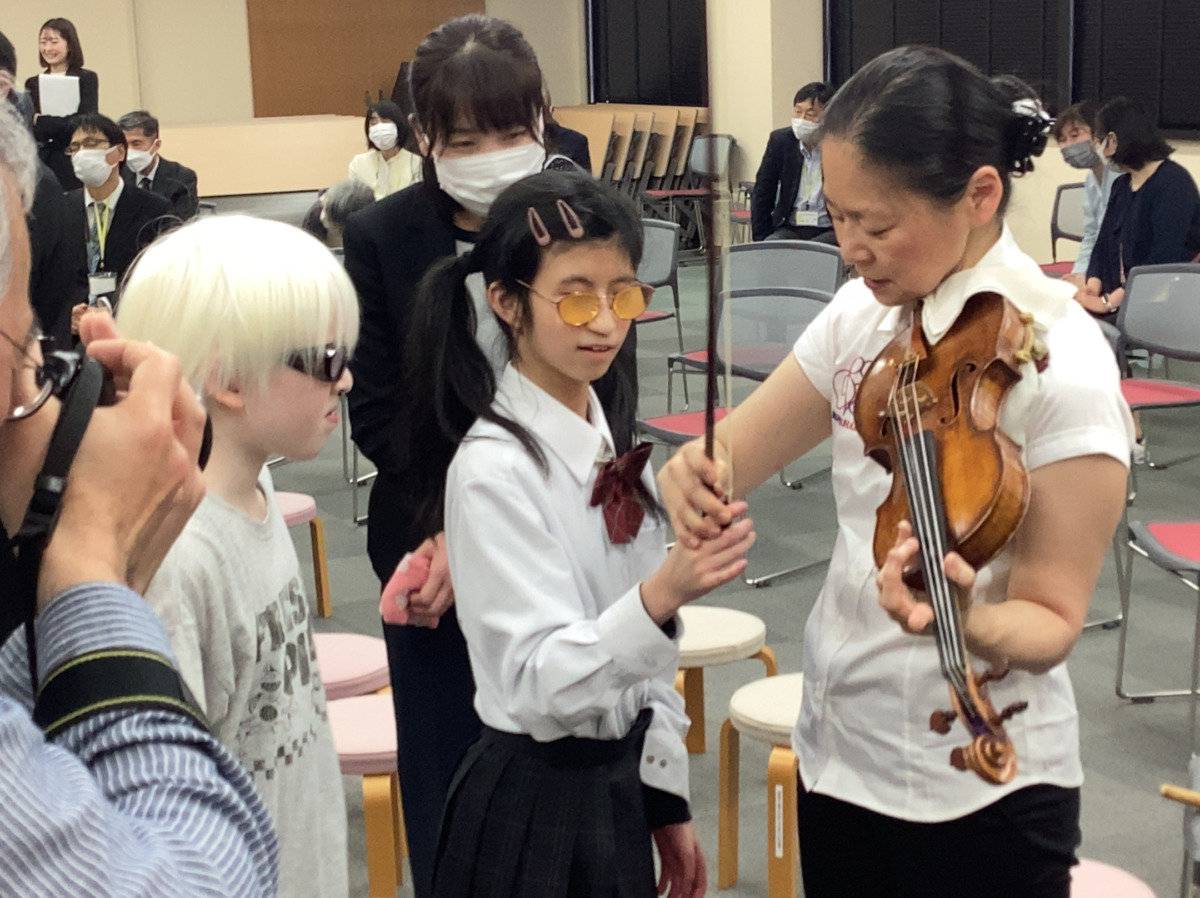 弓を持ち、演奏を体験