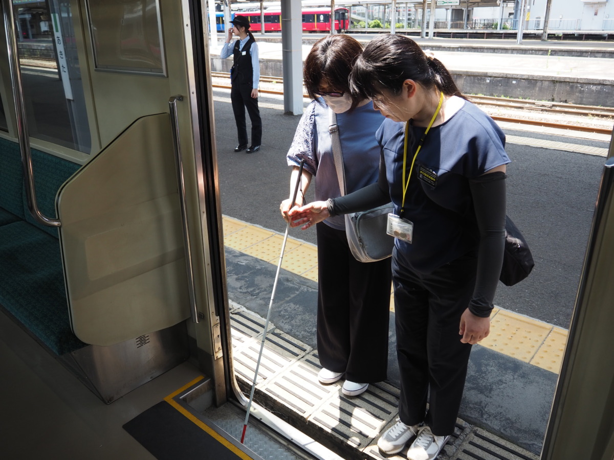 白杖で電車の乗降口を確かめながら乗車