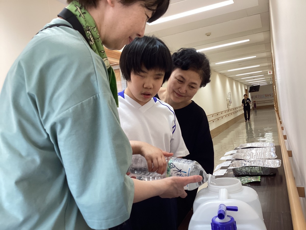 タンクに水を汲み、調理に使う共同の水場を設営