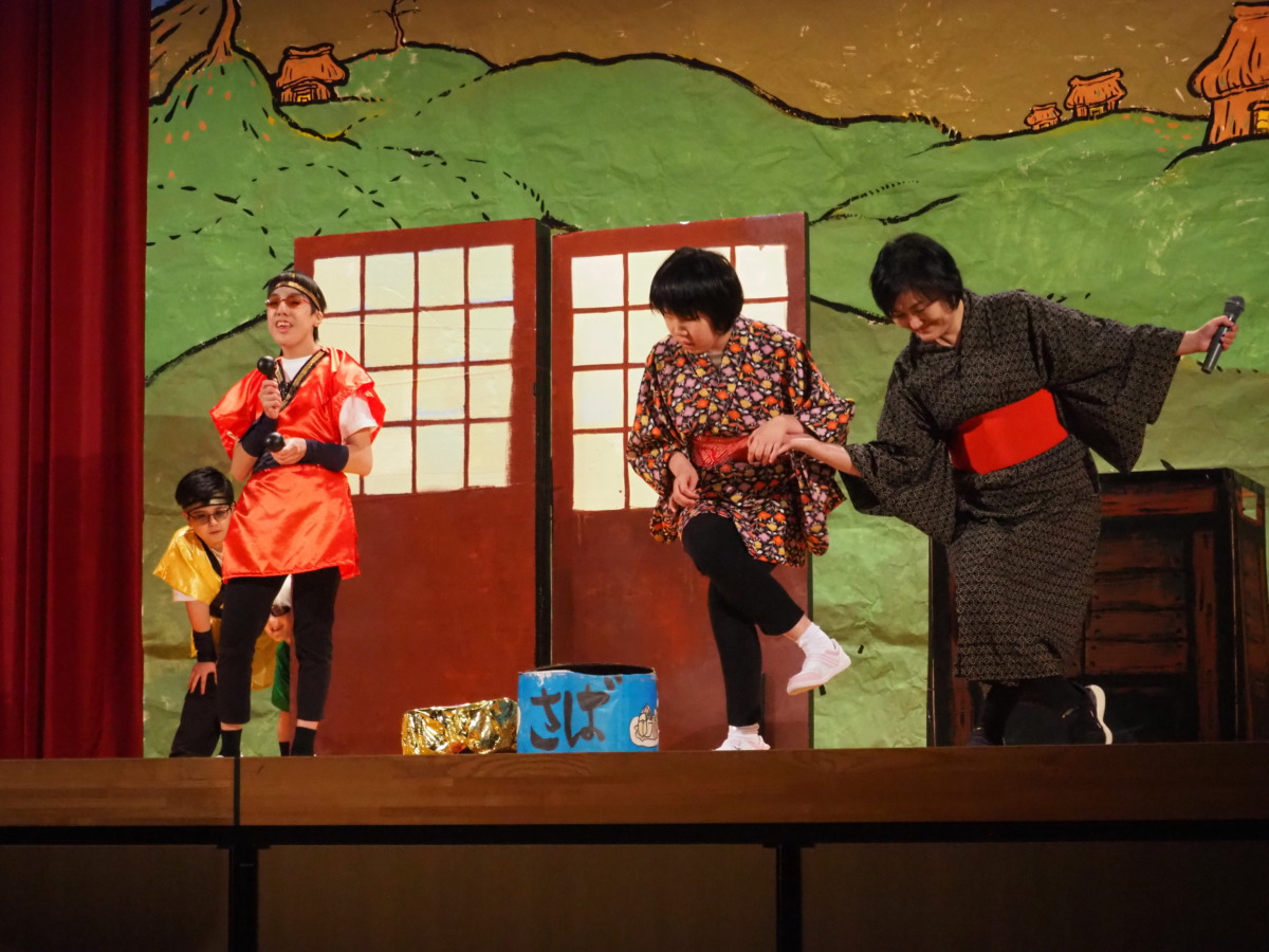 村人役の生徒が歌唱後にポーズをしている様子