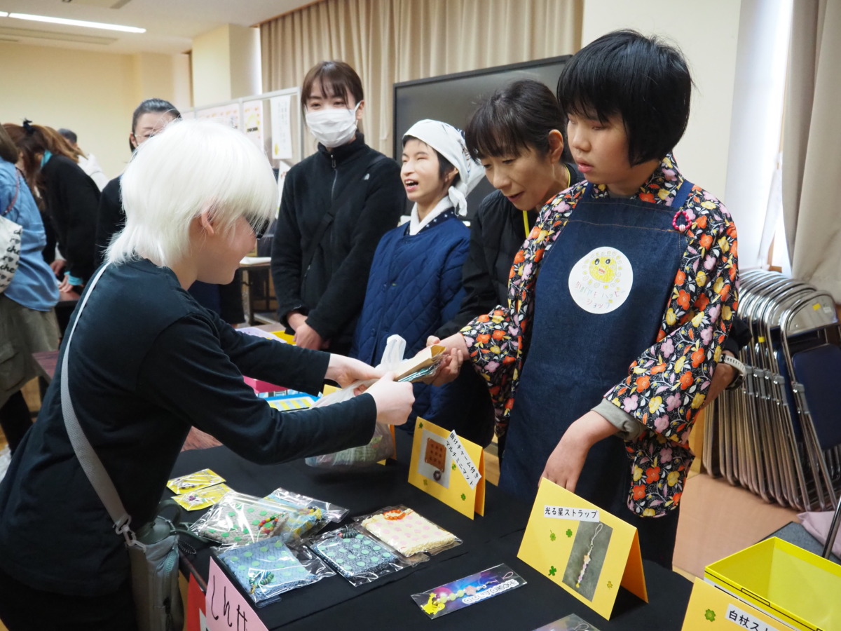 中学部の生徒が小学部の児童と、製品と代金をやりとりしている様子