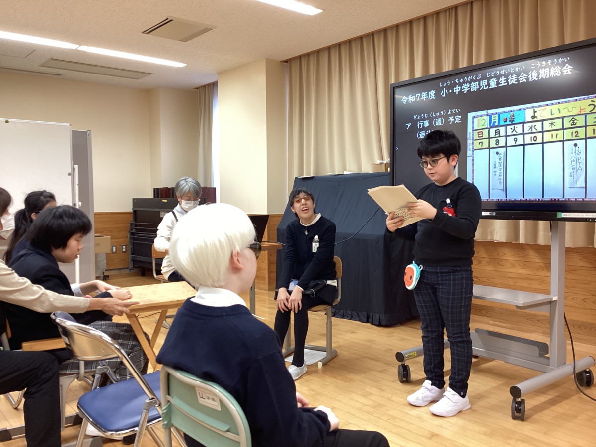 児童一名がモニターの前に立って、全体に向けて活動報告をしている様子