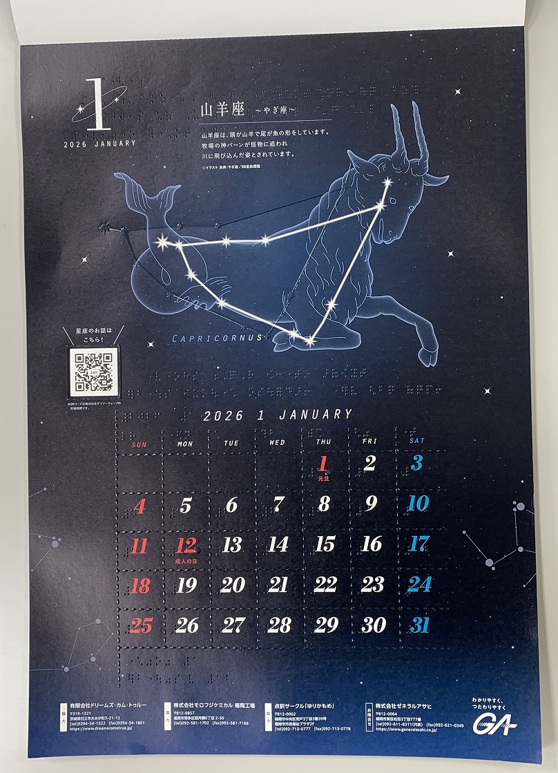 黒い星空の背景に平日は白文字、土曜日は青文字、日曜日と祝日は赤文字でカレンダー上に数字が並んでいる。山羊座が大きくプリントされており、各説明や数字に対応した点字が記載されている。