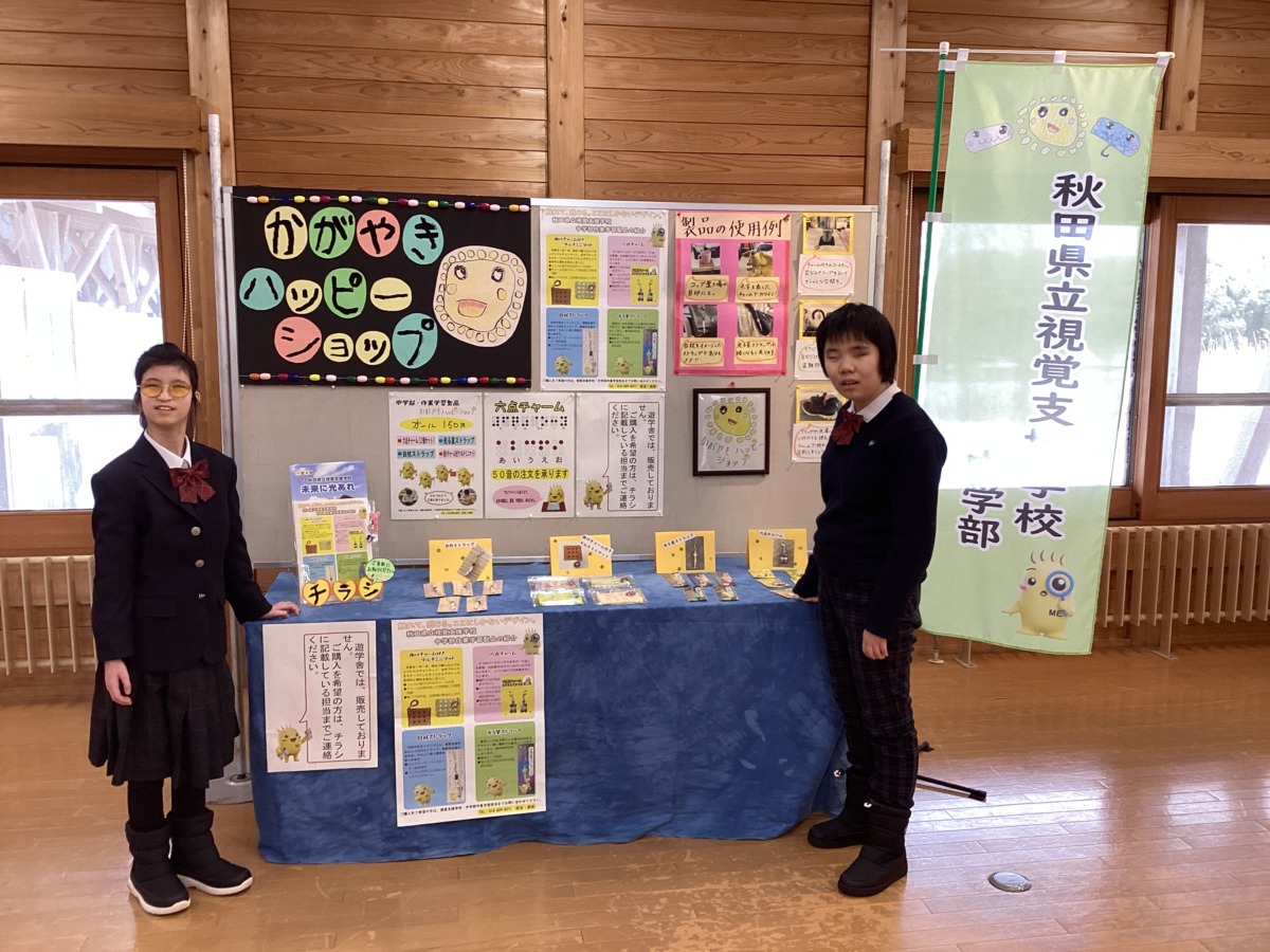 完成した展示コーナーを挟むようにして、生徒二名が記念撮影をしている様子