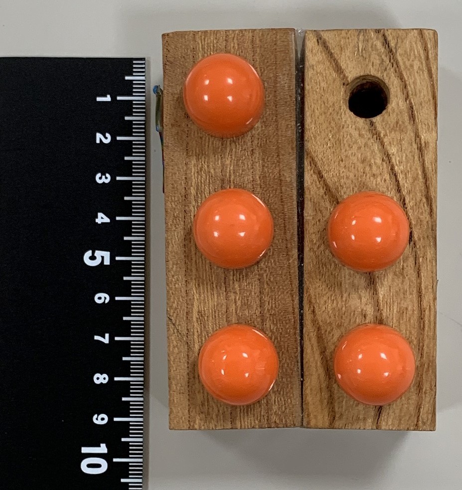 写真2　ペグを差し込む穴が3つ空けられた角材を2本接着したもの)