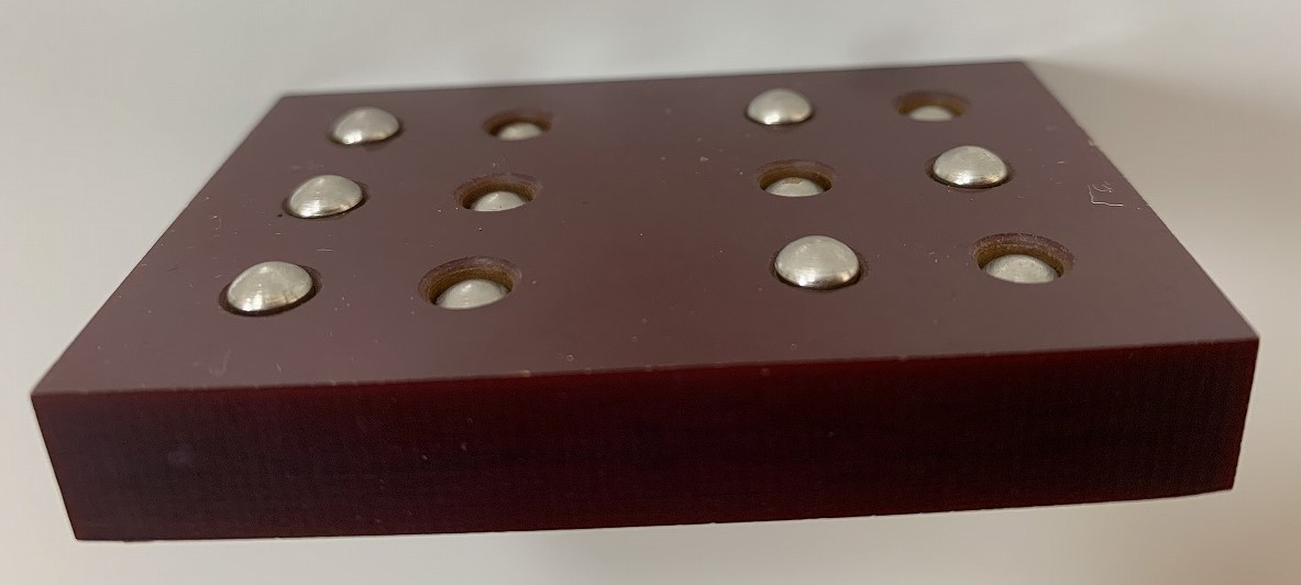 写真：いくつかの鋲を飛び出させている点字練習機