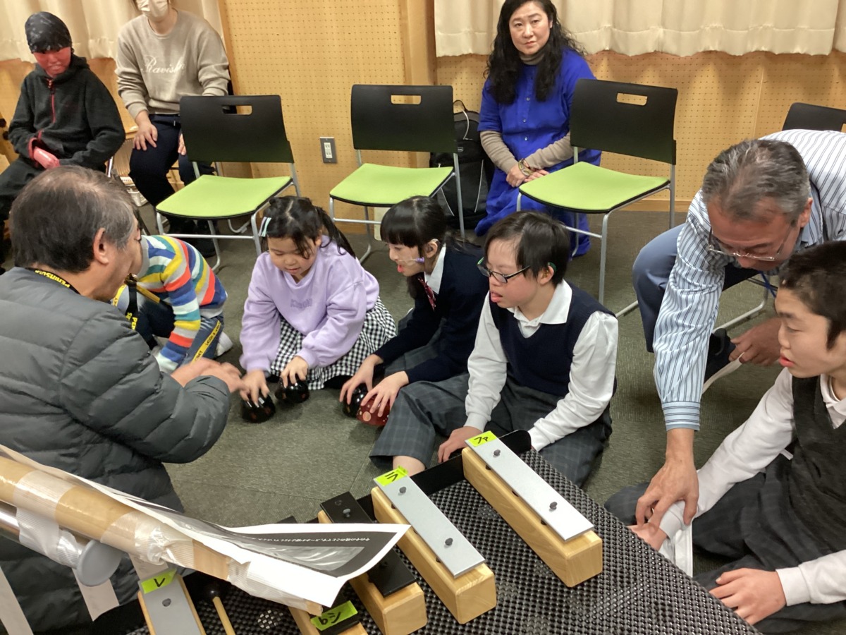 聴覚の生徒が、お椀を伏せる形で床のマットを叩き、競馬の音を再現している様子