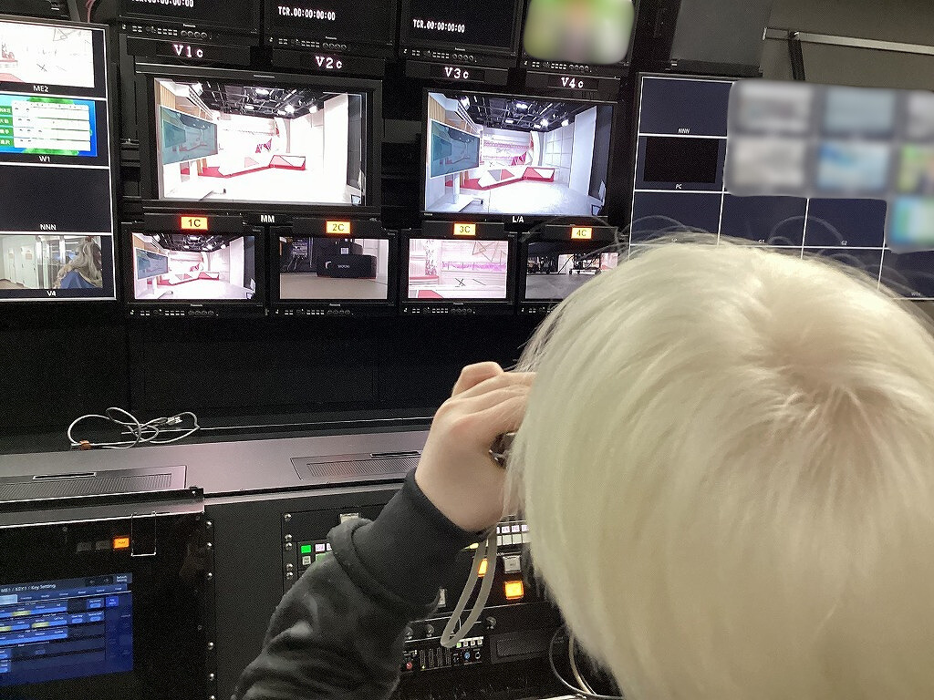 児童が調整室内の壁面に映る各カメラの画角を、単眼鏡で見ている様子