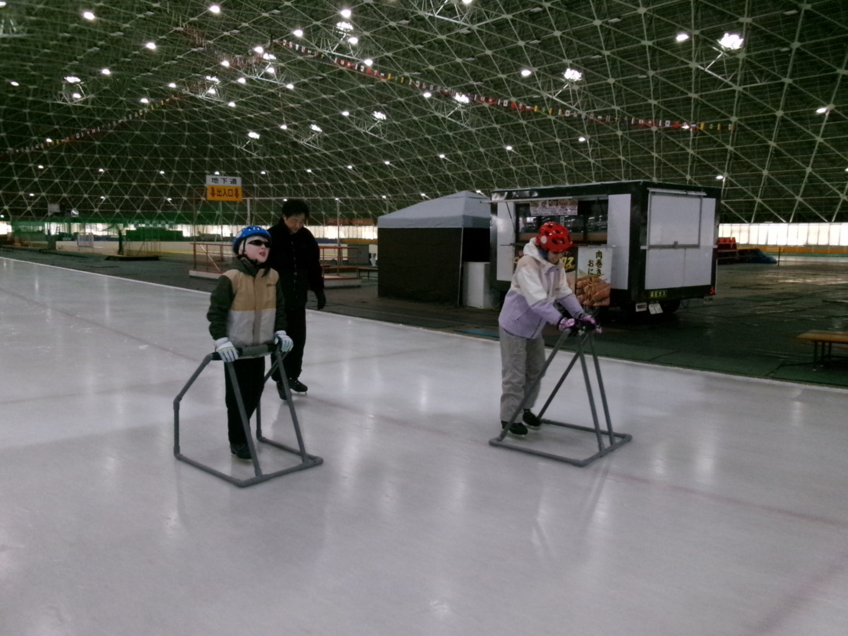 児童2名が、補助具を用いてリンクの向きに従って滑り始めた様子