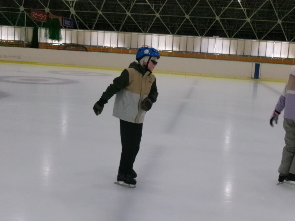 児童1名が、手すりや補助具を使わず、ホッケーリンクの中央を滑走している様子