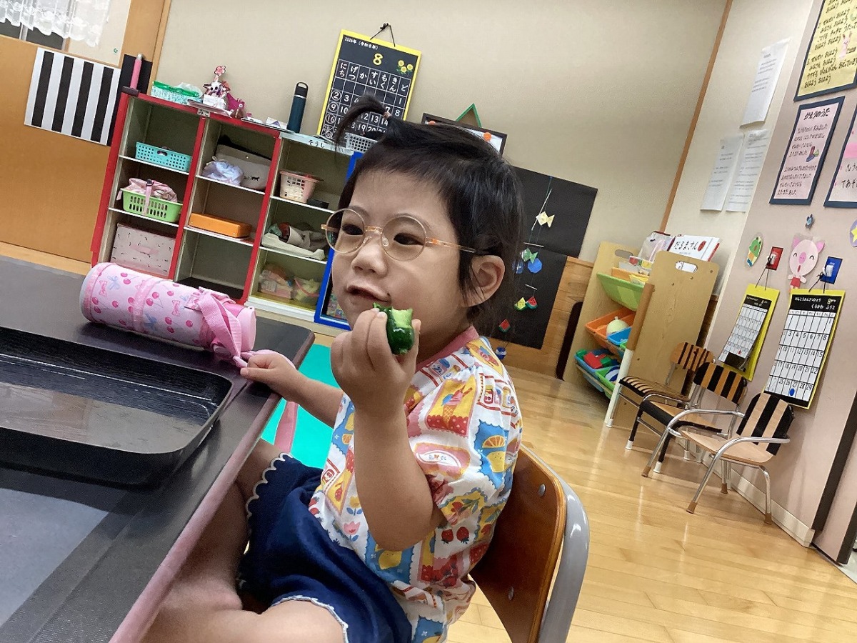 育てたきゅうりを実食する幼児