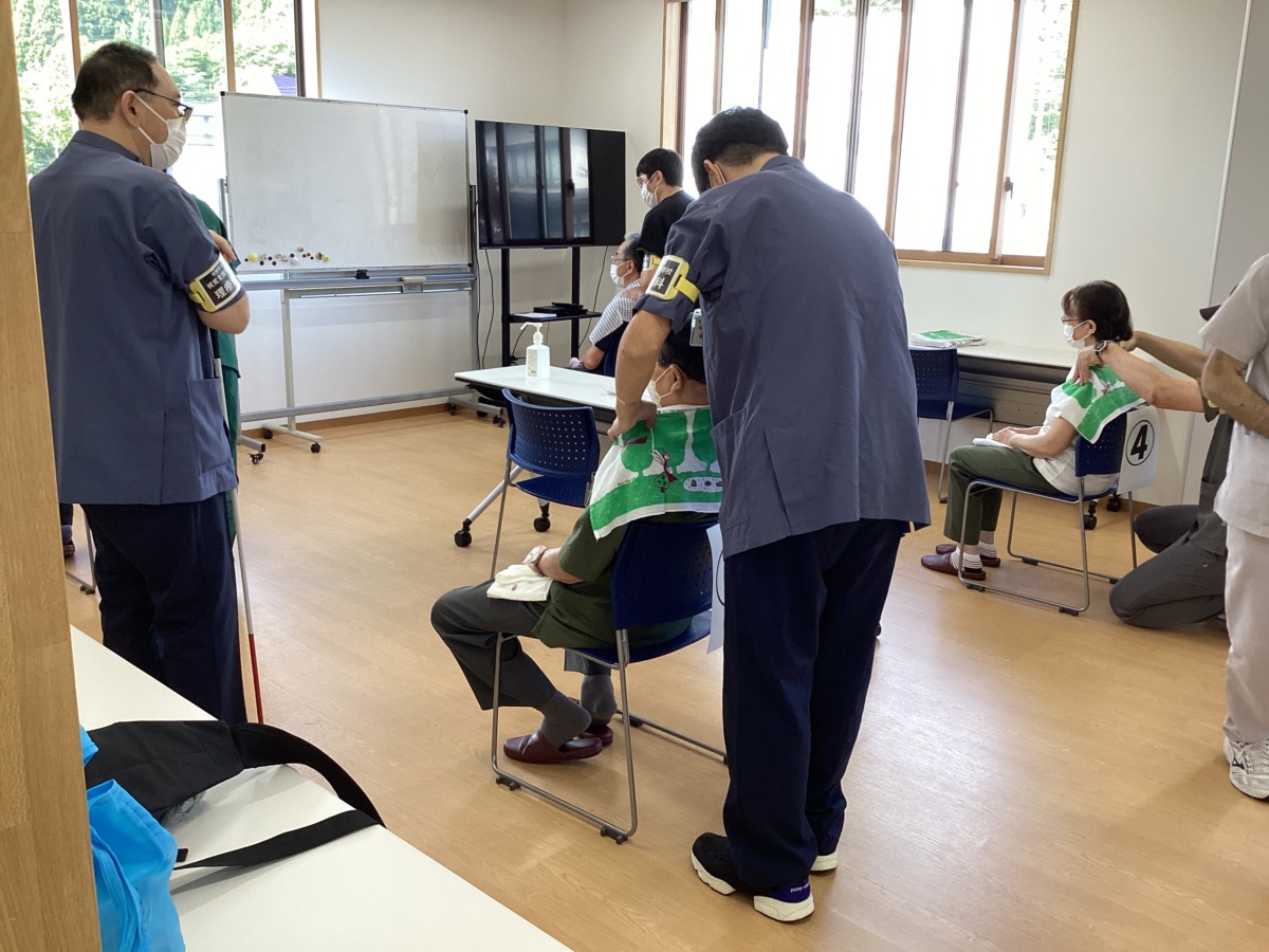 参加者に施術している生徒を、傍で見学する生徒