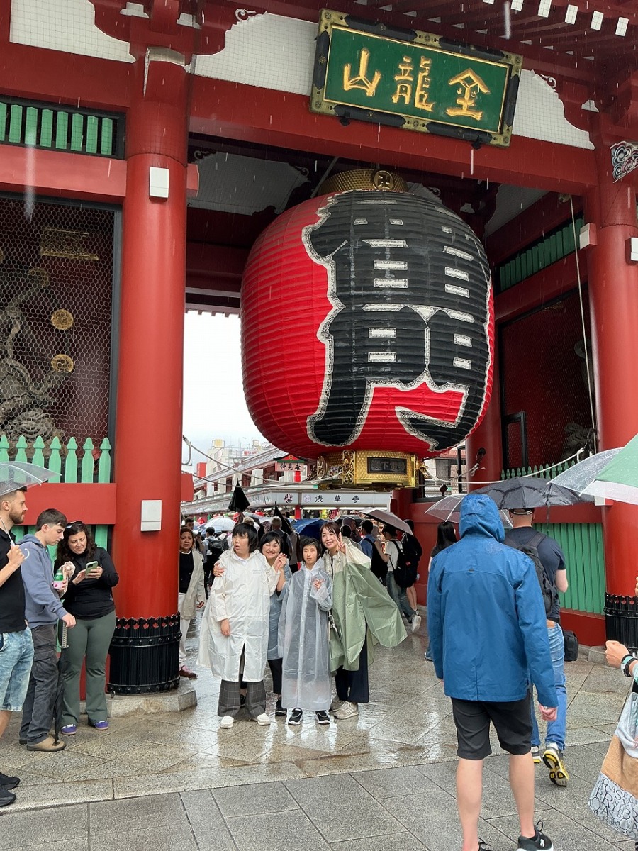 雷門と書かれた５メートルほどの巨大な提灯の前で並んでいる生徒2名と職員2名