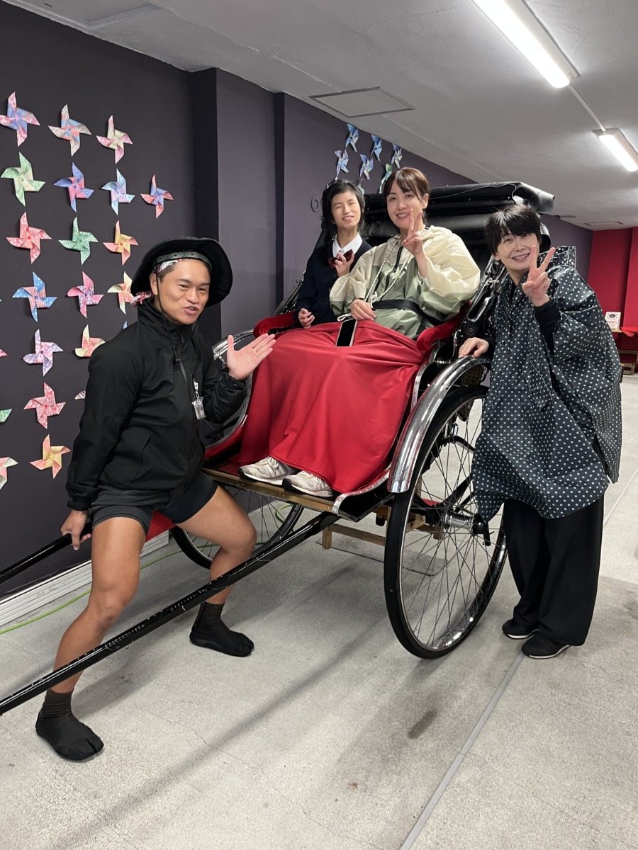 生徒1名と職員1名が人力車に乗り、そばに車夫の方と職員もう1名が並んでいる様子