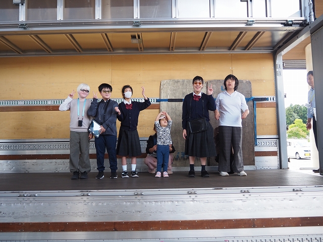 荷台が横に開いた方向に幼児児童生徒が一列に並んでいる様子。